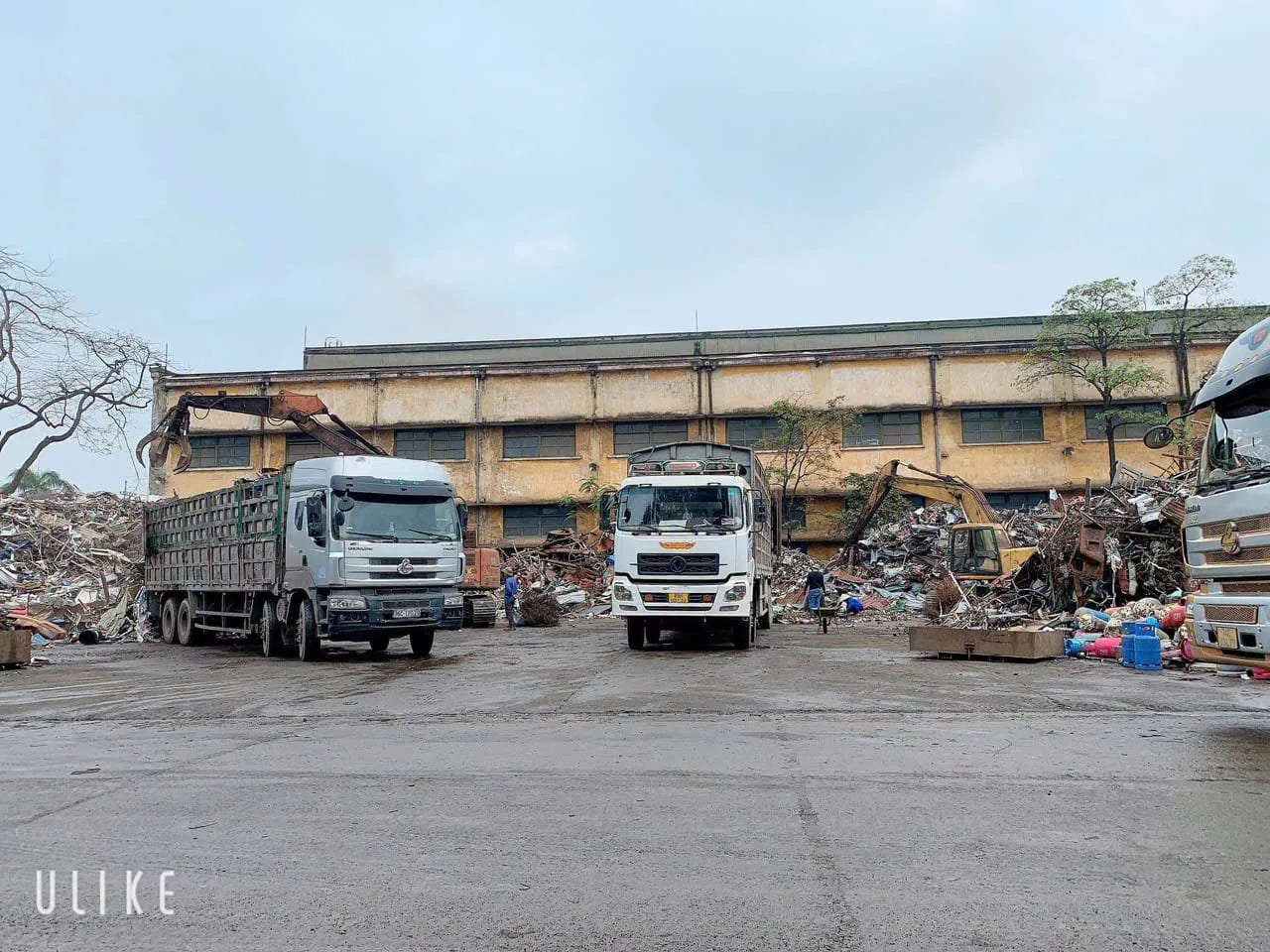 Xe tải và máy xúc gom hàng tại bãi thu mua phế liệu Thành Long